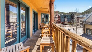 A wooden deck with chairs and tables, overlooking a town with buildings and hills. - Arapahoe Lodge #8130 By Summit County Mountain Retreats (Keystone)