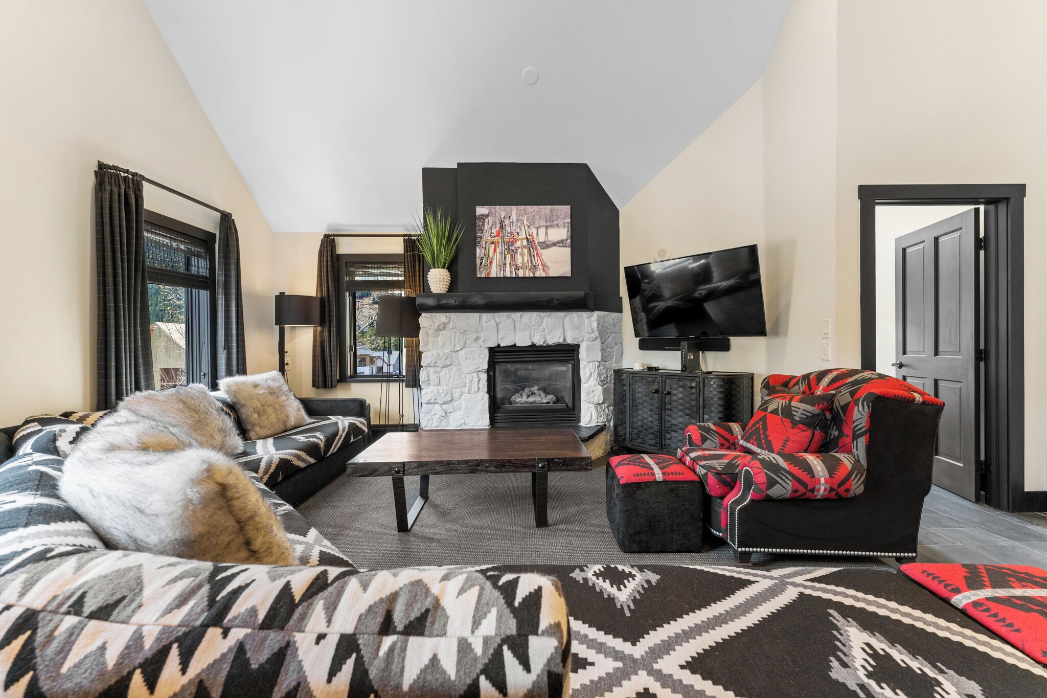Una sala de estar con chimenea, un sofá, una silla y una televisión.