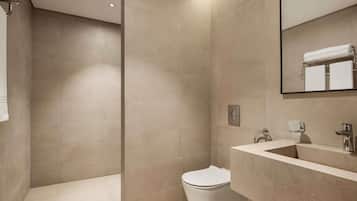 A modern bathroom with a toilet, sink, and shower area.