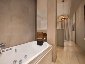 A modern bathroom with a large bathtub, a shower, and a hanging light fixture. - Shaden Resort (Al-'Ula)