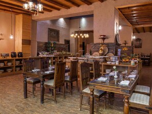 Un restaurante con mobiliario de madera, diversas opciones de comida a la vista y una decoración rústica.