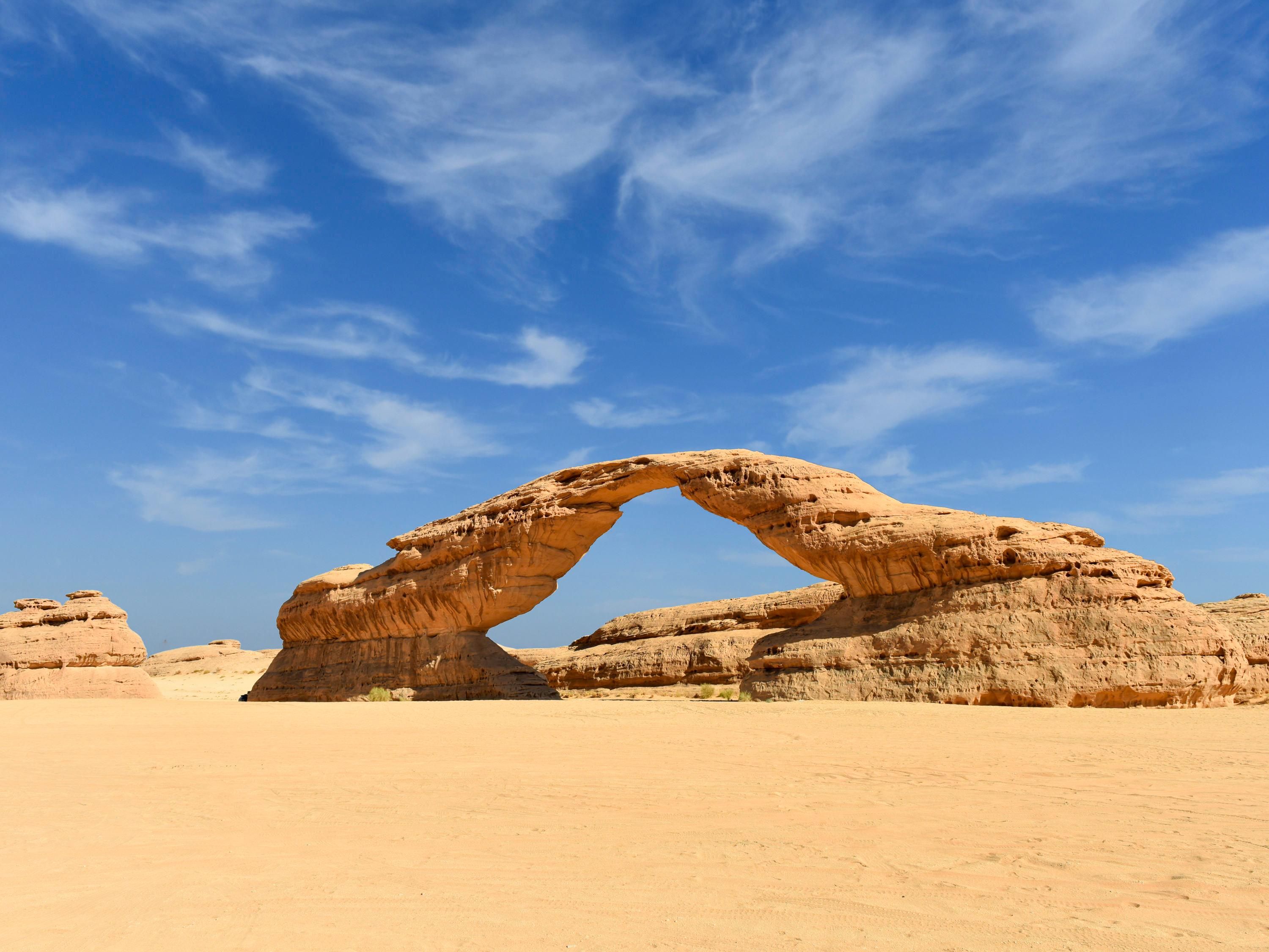 Formación natural de arco de roca en un paisaje desértico.