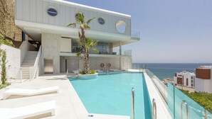 A modern building with a pool and a view of the sea. - Nova | Panoramic Sea View - Pool (Fuengirola)