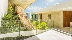 A modern interior with a glass railing, a concrete wall, and a wooden door. - Nova | Panoramic Sea View - Pool (Fuengirola)