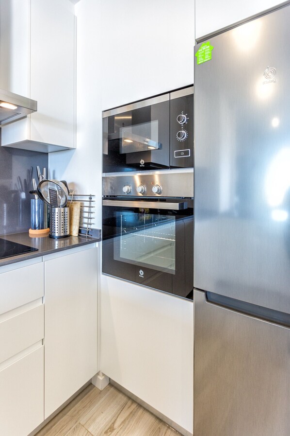 A modern kitchen with stainless steel appliances, including a refrigerator, oven, and microwave. - Han | Mountain view - pool - terrace (Estepona)