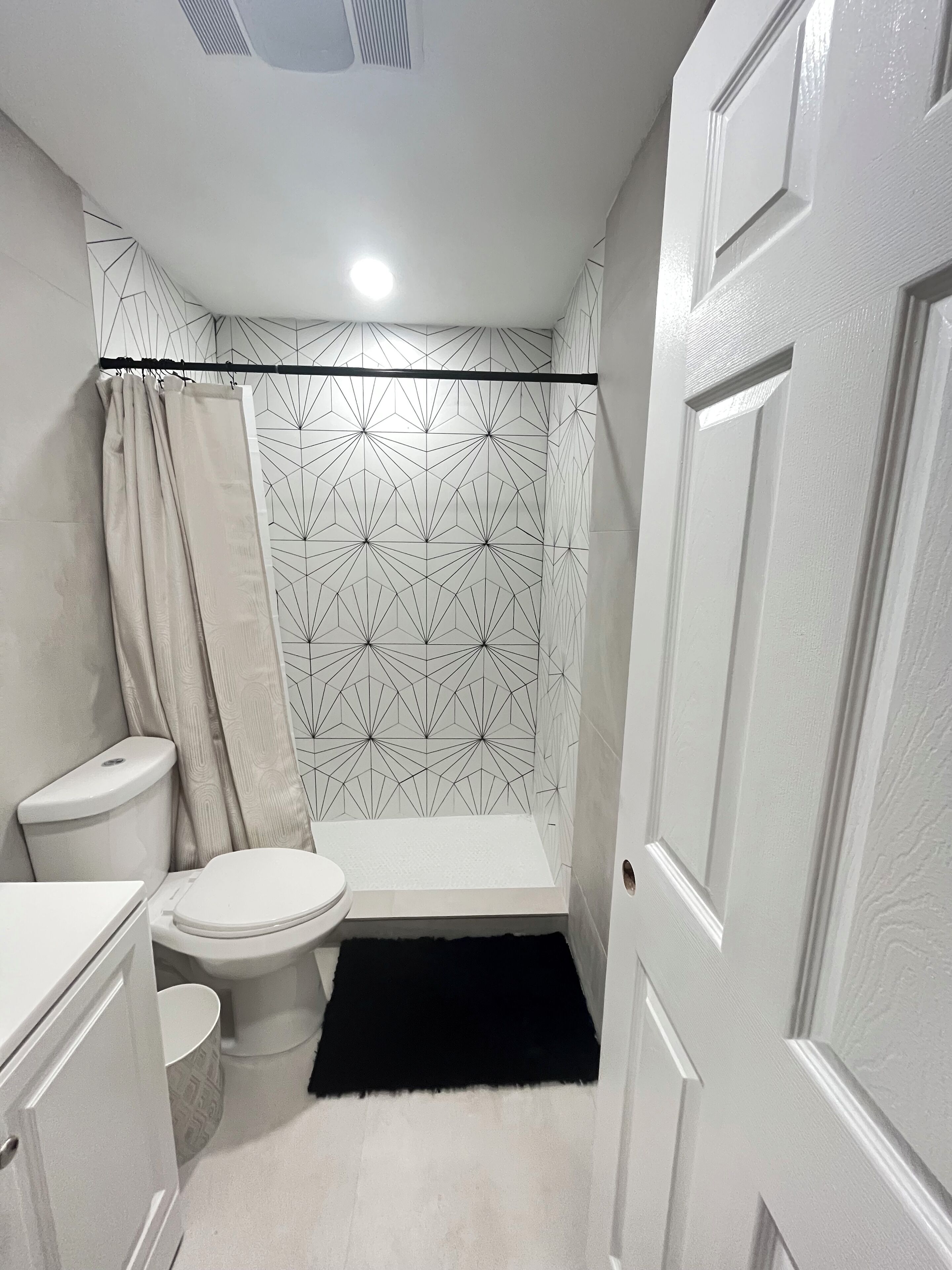 A bathroom with a toilet, sink, and shower area.