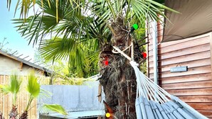 A hammock tied to a tree with a wooden deck and a wooden wall in the background. - Villa Canopée 6P - Piscine Chauffée/fibre/clim (Gujan-Mestras)