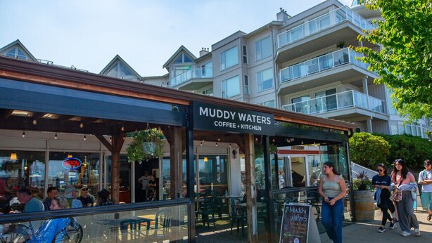 A coffee shop named Muddy Waters with outdoor seating and a view of residential buildings in the background. - Wanderlust | Studio Suite with Private Patio (Harrison Hot Springs)