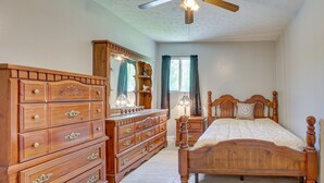 Ein Schlafzimmer mit einem hölzernen Bett, einem Schminktisch und einem Spiegel.