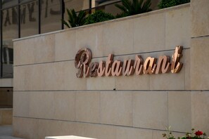 A building facade with a large, three-dimensional sign that reads 'Restaurant.' - Jeddah Homes Boutique Hotel (Amman)