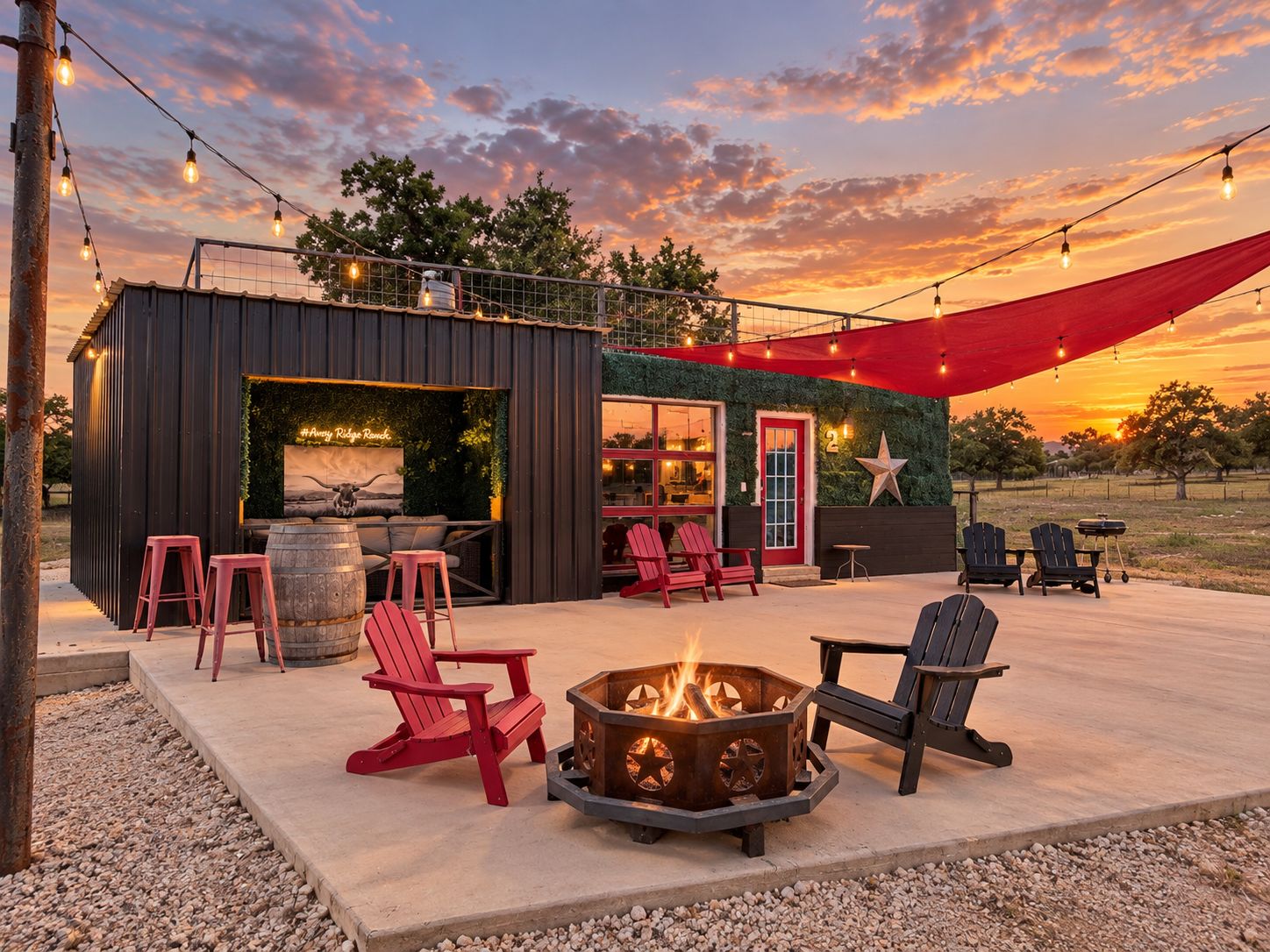 A rustic outdoor seating area with Adirondack chairs, a fire pit, and string lights against a sunset backdrop.