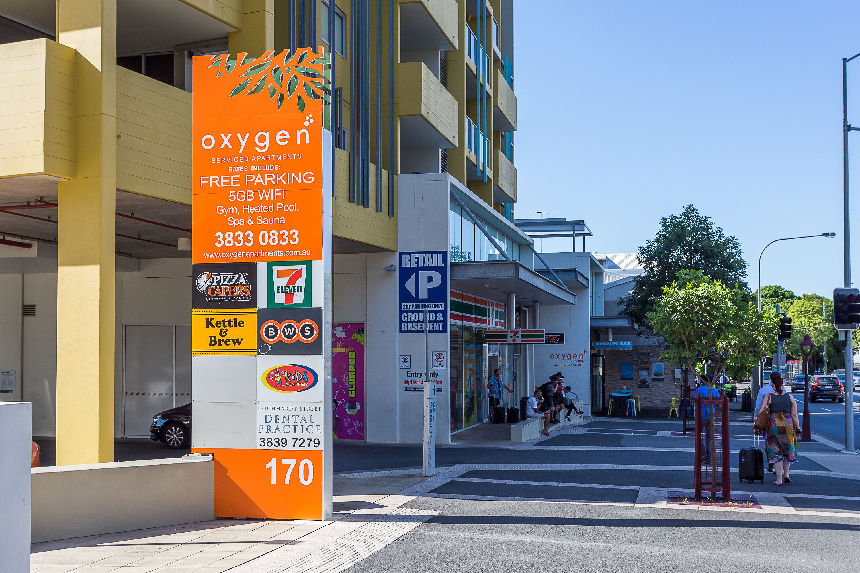 Ein Gebäude mit einem Schild, das Apartments mit Sauerstoff, kostenlose Parkplätze, 5G-WLAN, ein Fitnessstudio, Pool mit Wärmepumpen und Spa & Sauna bewirbt.
