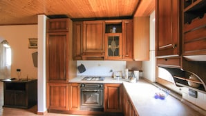 A kitchen with wooden cabinets, a gas stove, an oven, and a sink. - Beautiful home in Sesta Godano (Sesta Godano)