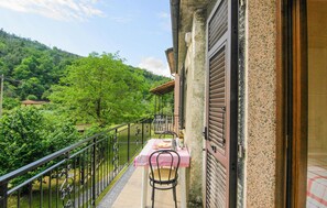 A balcony with a table and chairs, overlooking a lush green landscape and a mountain. - Beautiful home in Sesta Godano (Sesta Godano)