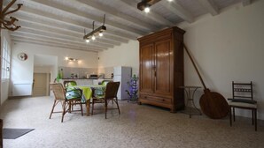 A spacious kitchen with a dining area, wooden cabinets, and a hanging light fixture. - Le Tilleul - JALOGNY (JALOGNY)