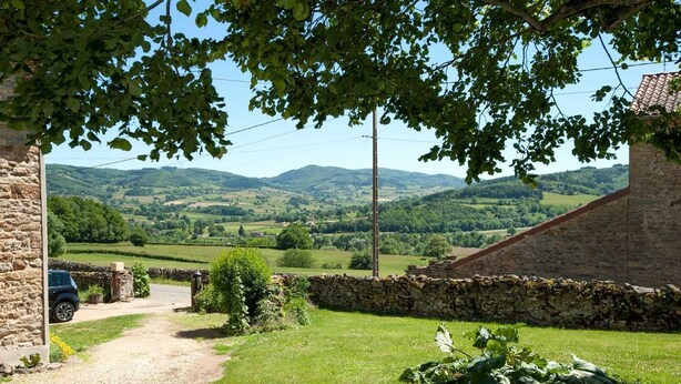 A rural landscape with a stone wall, a gravel path, and a parked car. - Le Tilleul - JALOGNY (JALOGNY)