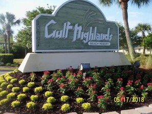 Welcome to Gulf Highlands Beach Resort, where lush gardens surround the entrance.