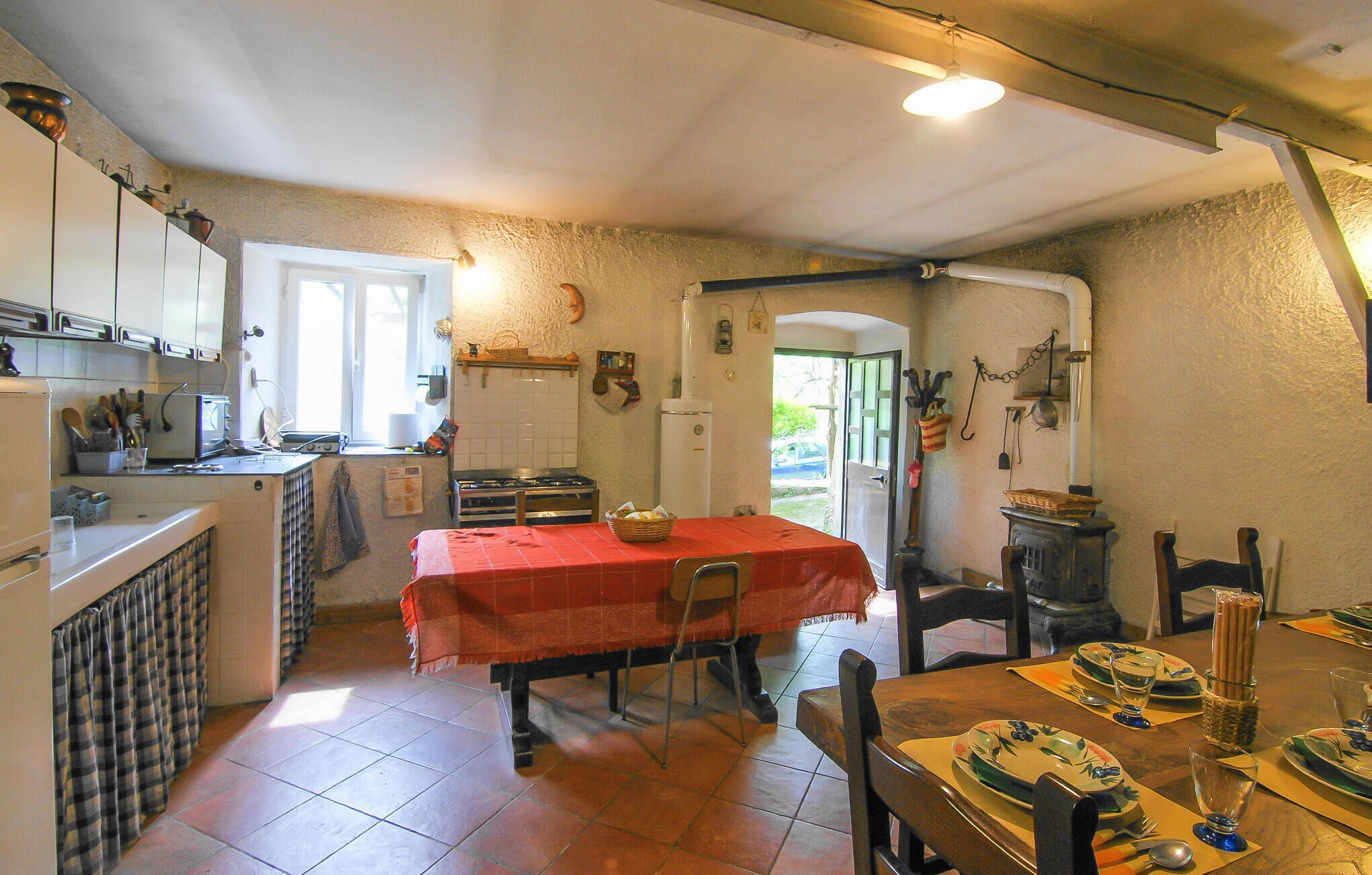 A kitchen with a dining table set for two, a stove, and a refrigerator.