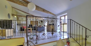 A staircase with ornate metal railings and a wooden ceiling beam.