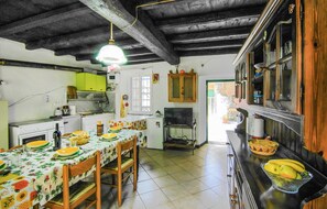 Une cuisine équipée d’une table à manger pour quatre personnes, d’un réfrigérateur, d’une cuisinière et d’un évier.