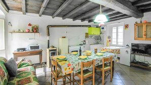 A cozy kitchen with a dining table set for four, a wooden ceiling, and basic kitchen appliances. - 1 bedroom gorgeous apartment in Codivara (Codivara)