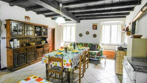A kitchen with a dining table set for four, wooden cabinets, a stove, and a window with a view. - 1 bedroom gorgeous apartment in Codivara (Codivara)