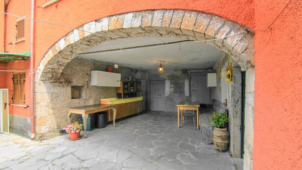 A rustic kitchen with stone walls, a wooden table, and a hanging light fixture. - 1 bedroom gorgeous apartment in Codivara (Codivara)