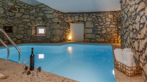 A stone-walled indoor pool with a clear blue water surface, a metal ladder, and a small window. - Lovely home in Moscenicka Draga with WiFi (Moscenicka Draga)