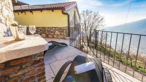 A balcony with a stone wall, a metal railing, and a view of a mountainous landscape. - Lovely home in Moscenicka Draga with WiFi (Moscenicka Draga)