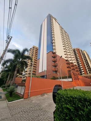 Stunning high-rise building with a unique design, featuring multiple balconies and a beautiful outdoor setting.