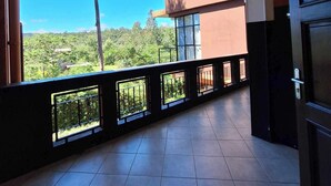 A spacious balcony with a view of greenery and a clear sky. - Andasibe Cyperus Hotel (Andasibe)