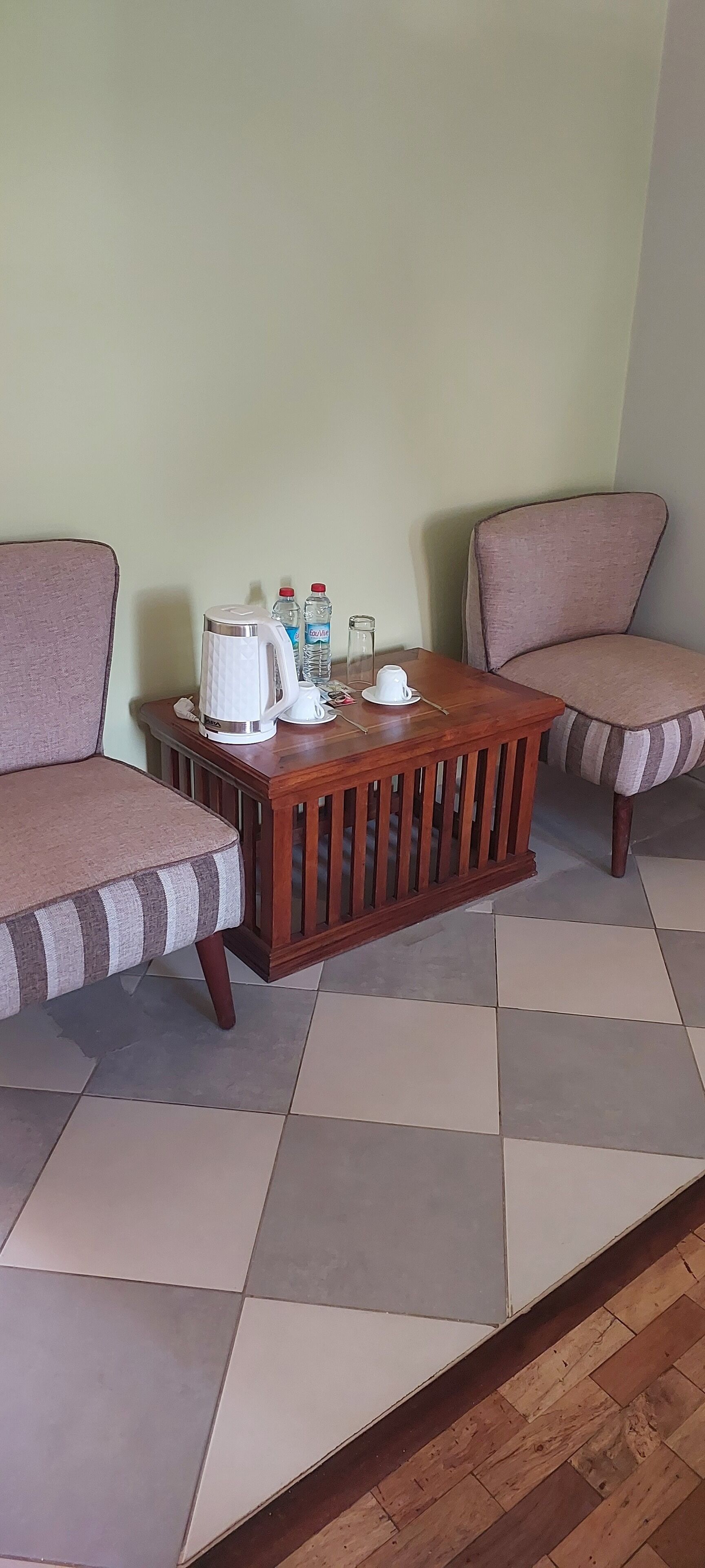 A room with two sofas, a wooden coffee table, and a tiled floor.