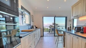 Une cuisine moderne avec vue sur l’extérieur, un coin bar et un espace repas.