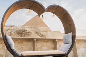 A heart-shaped seating area with a view of a pyramid. - Villa Khufu Pyramids Hotel (Giza)
