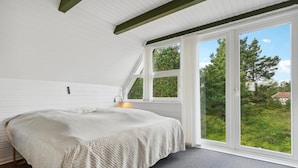 A bedroom with a bed, a window, and a view of greenery outside. - Lake front home in Rømø with WiFi (Rømø)
