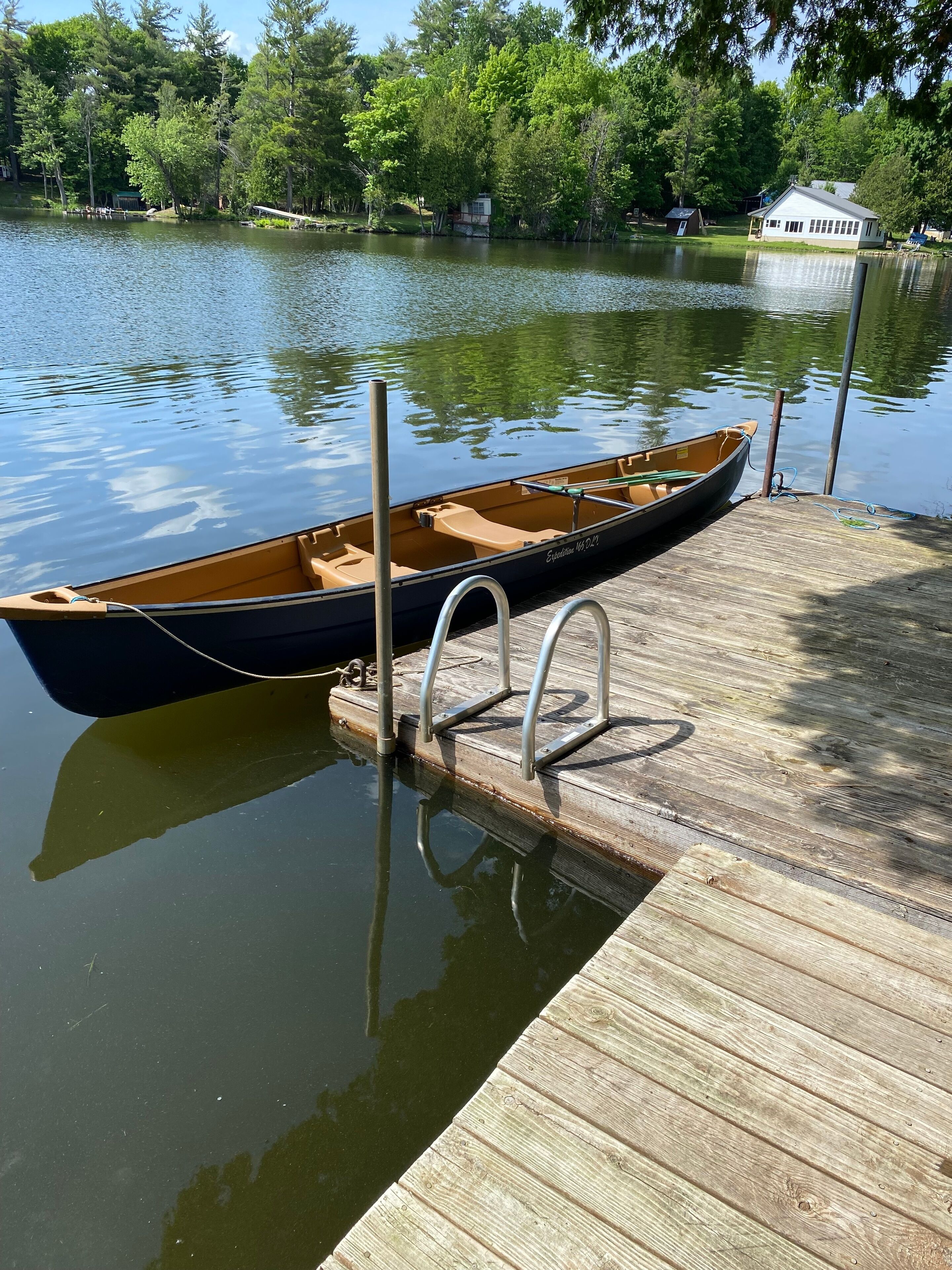 Een houten steiger met een roeiboot aan het einde.