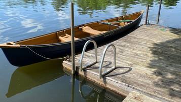 Een houten steiger met een roeiboot aan het einde.