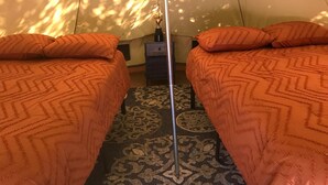 A room with two beds, a patterned rug, and a nightstand. - Sequoia Jewel -16 Foot Bell Tent with double beds. 4.5 to Sequoia National Park. (Three Rivers)