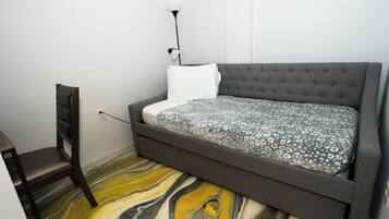 Ein Schlafzimmer mit einem Bett, einem Sessel und einem Boden mit Marmoroptik.
