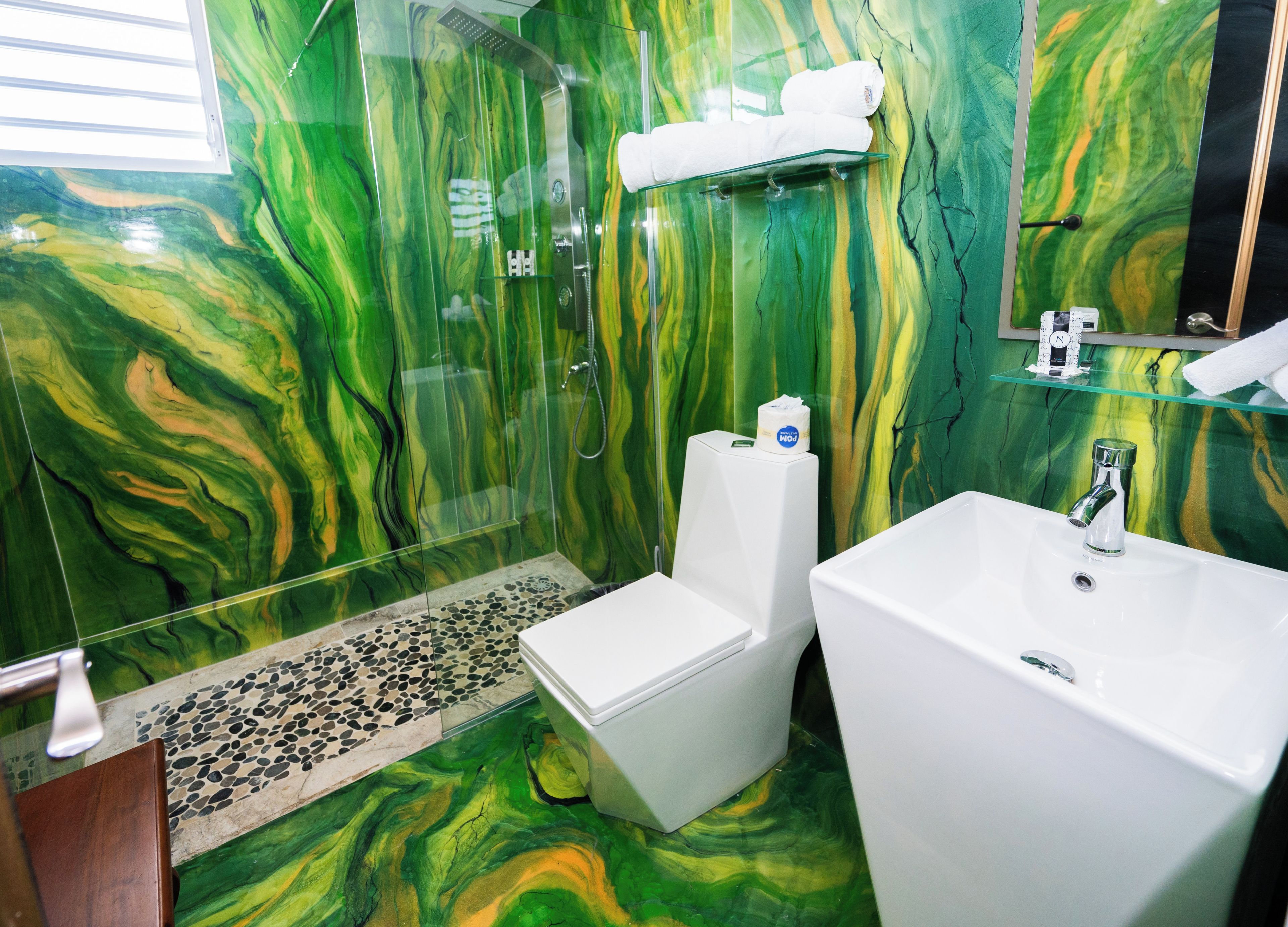 Une salle de bain avec une douche à parois de verre, un lavabo blanc et des toilettes.