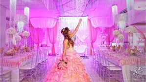 A wedding venue with a pink and white color scheme, featuring a bride in a pink dress, chandeliers, and floral arrangements. - Luxury Puerto Caribe Boutique Hotel (Aguada)