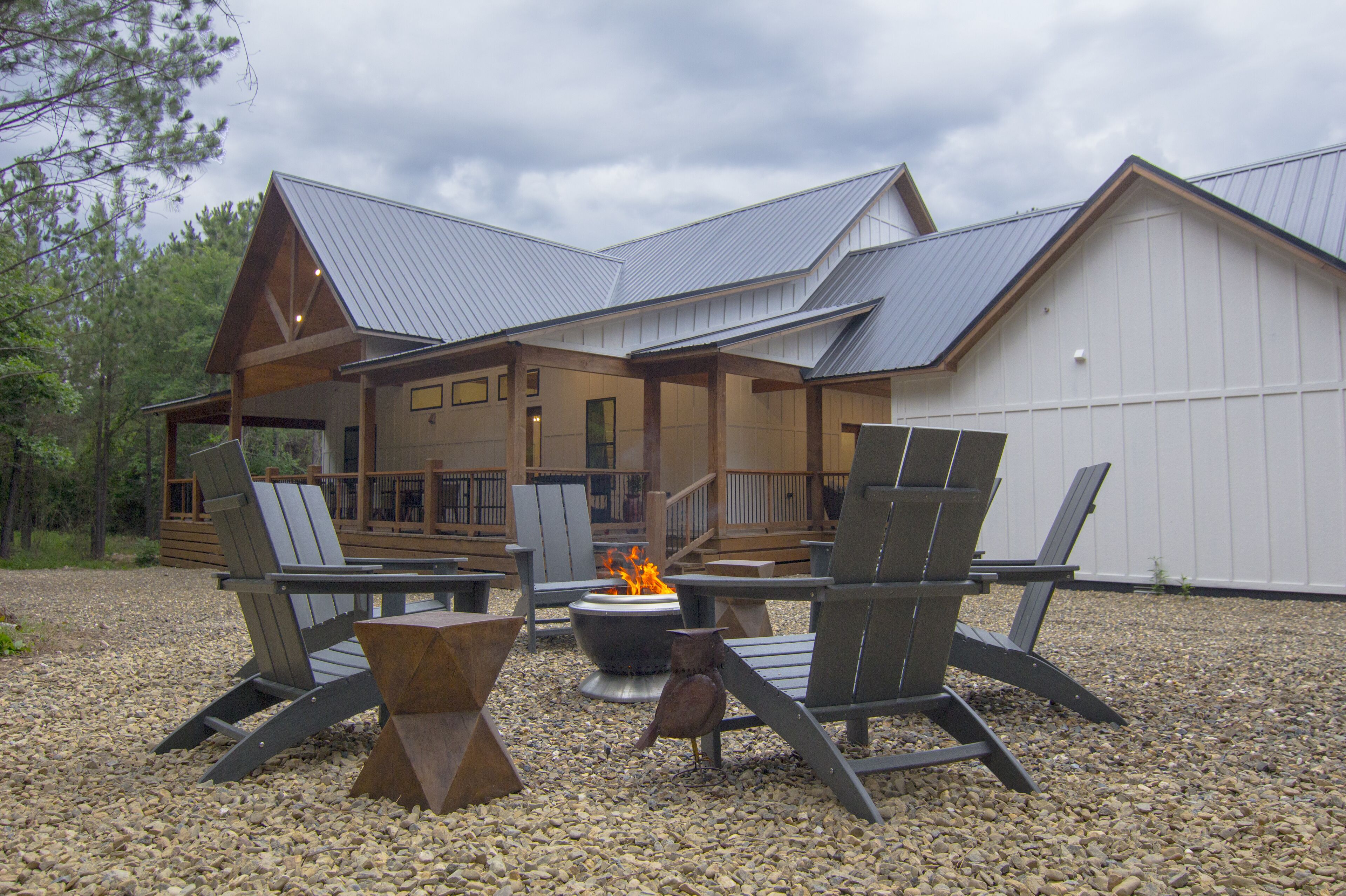 A lodge with a covered deck, outdoor seating, and a fire pit.