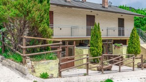 Un bâtiment à deux étages doté d’un balcon, d’une clôture en bois et d’une allée gravillonnée.