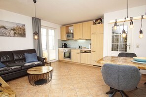 Una sala de estar moderna con sofá, una mesa de centro y comedor.