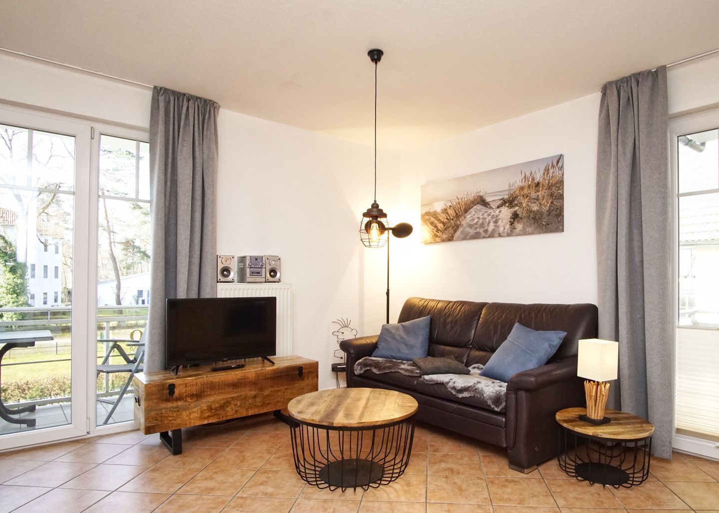 A modern living room with a leather sofa, wooden coffee table, and a flat-screen TV.
