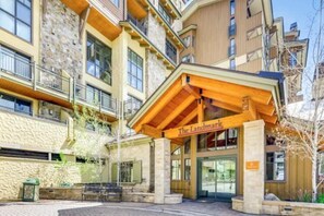 A multi-story hotel with a stone facade, balconies, and a wooden entrance canopy labeled 'The Landmark.'