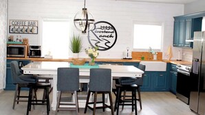 A modern kitchen with a central island, bar seating, and a coffee bar. - Riverbend Ranch*Smith Lake Family Fun!*Dog Yard! (Crane Hill)