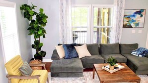 A living room with a sofa, armchair, coffee table, and a potted plant. - Riverbend Ranch*Smith Lake Family Fun!*Dog Yard! (Crane Hill)