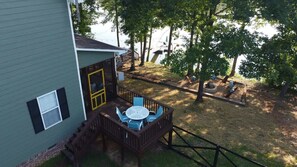 Una casa con terraza, un espacio pequeño para sentarse al aire libre y un muelle para barcos.