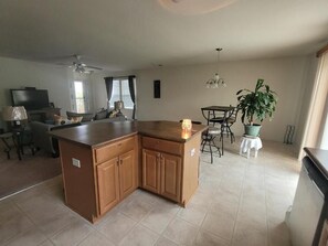 Cozy living area with a large kitchen island, dining table, and mounted TV.